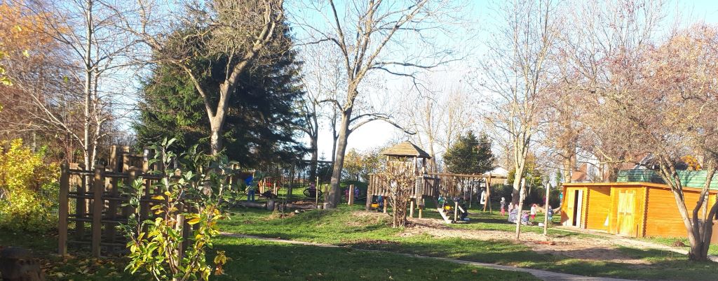 Kinder spielen in der Herbstsonne auf dem Hof der Kita "In der kleinen Schule"
