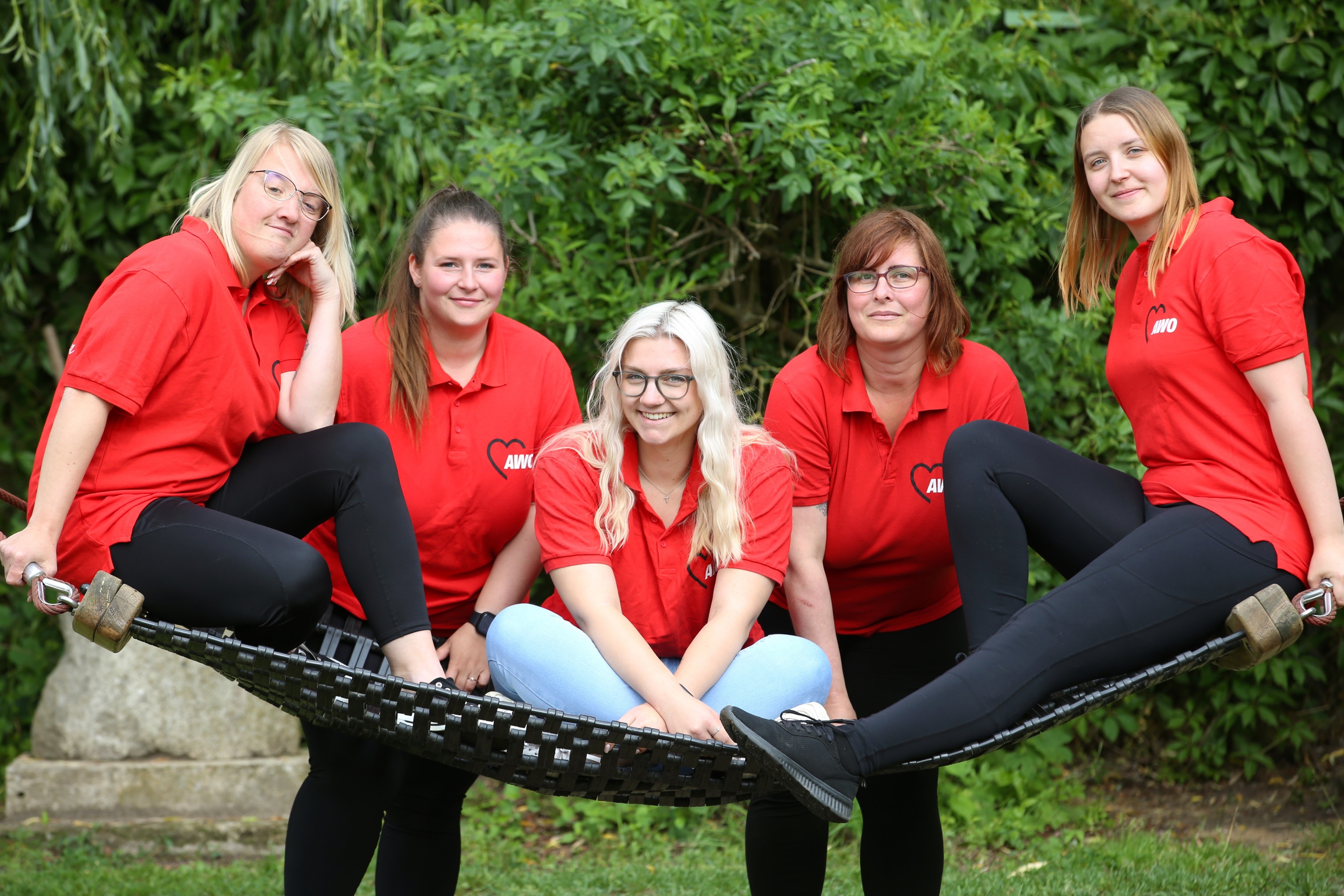 Mitarbeiterinnen der Kiat Sonnenschein sitzen zusammen auf einer großen Hängematte